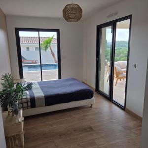 a bedroom with a bed and a view of a patio at Villa View in Combaillaux
