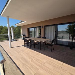 a patio with a table and chairs on a deck at Villa View in Combaillaux