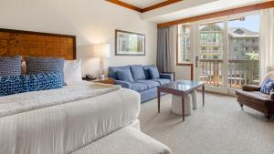 a bedroom with a bed and a couch and a table at 347 Lodge At Spruce Peak Ski In Ski In Ski Out King Studio By Stowe Mountain Rentals in Stowe +15 photos