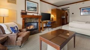 a living room with a couch and a fireplace at 347 Lodge At Spruce Peak Ski In Ski In Ski Out King Studio By Stowe Mountain Rentals in Stowe