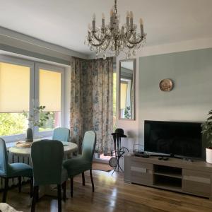 a living room with a dining table and a television at Apartament Classic in Malbork
