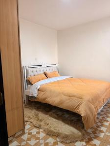 a bedroom with a bed with orange pillows on it at 2020 suites utawala in Nairobi +17 photos