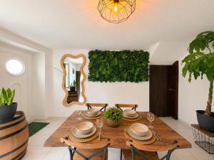 a dining room with a wooden table and a mirror at La Jungle du Vernet, Ambiance Tropicale in Le Vernet