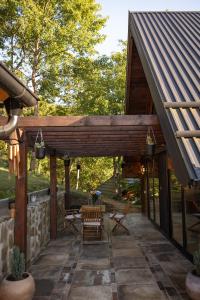 an outdoor patio with a wooden pergola at Alpas forest house in Kuršumlija