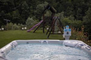 a hot tub in a yard with a playground at Alpas forest house in Kuršumlija