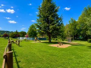 a park with a tree and a playground at La Jungle du Vernet, Ambiance Tropicale in Le Vernet