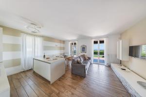 a kitchen and living room with a couch and a table at Borgo Stropea by Whale Homes in Soiano del Lago