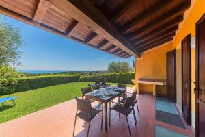 a patio with a table and chairs on a patio at Borgo Stropea by Whale Homes in Soiano del Lago