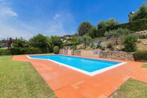 a swimming pool in a yard next to a garden at Borgo Stropea by Whale Homes in Soiano del Lago