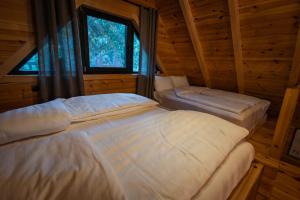 a bedroom with two beds in a log cabin at Alpas forest house in Kuršumlija +37 photos