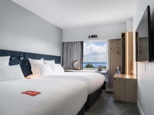 a hotel room with two beds and a window at ibis Rotorua in Rotorua