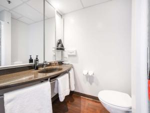a bathroom with a sink and a toilet and a mirror at ibis Rotorua in Rotorua +30 photos