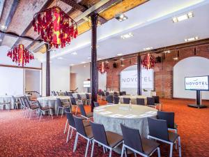 a conference room with tables and chairs and a stage at Novotel Cardiff Centre in Cardiff +260 photos