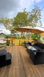 a wooden deck with chairs and an umbrella at Villa Venus in Ferizaj