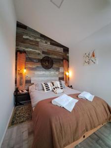 a bedroom with two beds and a wooden wall at 4 Rest in a warm and comfortable loft in Coihaique