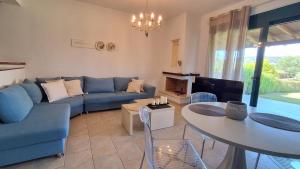 a living room with a blue couch and a table at Elthea Villa in Skala Fourkas