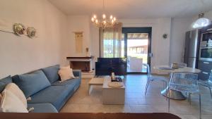a living room with a blue couch and a table at Elthea Villa in Skala Fourkas