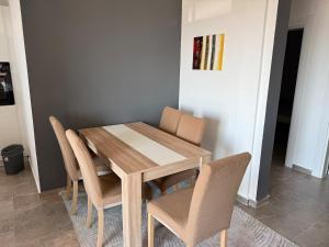 a wooden table and chairs in a room at Ninas Seaview Apartment in Bar