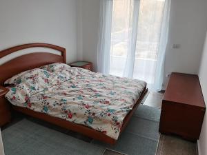 a bedroom with a bed and a table and a window at Ninas Seaview Apartment in Bar