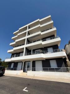 a tall white apartment building with a parking lot at Ninas Seaview Apartment in Bar
