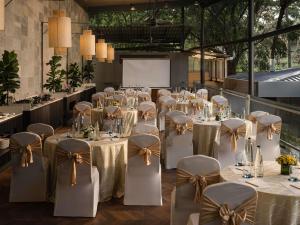a room with white tables and chairs with bows at Grand Mercure Bangalore - An Accor Brand in Bangalore +93 photos