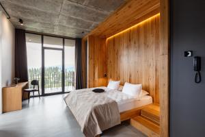 a bedroom with a bed with a wooden wall at Шпиці boutique hotel & SPA in Yablunytsya +80 photos