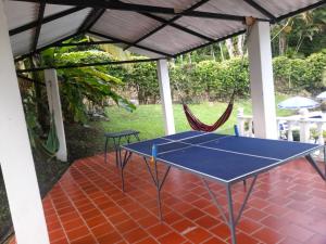 a ping pong table on a patio with a hammock at Finca Hotel Campestre Salitre Villeta in Villeta