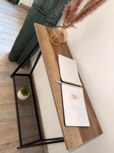 a wooden table with a notebook and a pen on it at Le Charme d'Anduze in Anduze