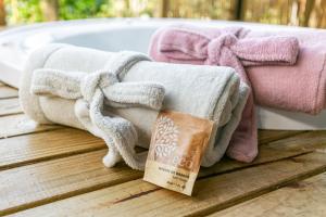 a pile of towels sitting on a table with a bath tub at Chalé Sattva - Vista Mar e banheira de Hidromassagem quente - Florianópolis - SC - BR in Florianópolis