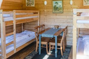a dining room with a table and bunk beds at Alevi Camping in Stöllet