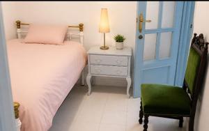 a bedroom with a bed and a blue door and a chair at Casa granada in Atarfe