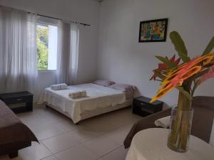 a bedroom with a bed and a vase of flowers on a table at Finca Hotel Campestre Salitre Villeta in Villeta +20 photos