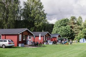 a group of cottages in a park with a car at Alevi Camping in Stöllet