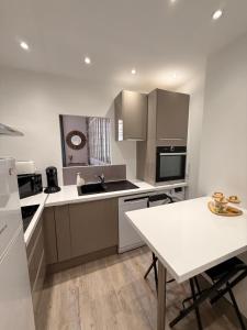 a kitchen with a table and a white counter top at Le Charme d'Anduze in Anduze