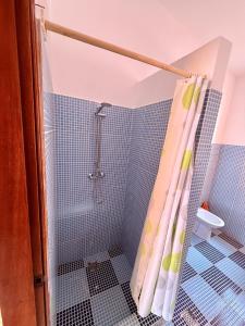 a bathroom with a shower with blue tiles at Ocean Pearl Beach House in Morro +2 photos