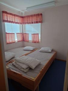two beds in a room with a window at Höghedens camping in Älvsbyn