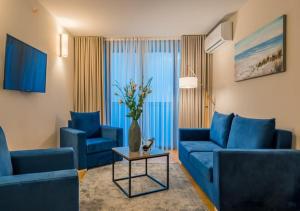 a living room with two blue couches and a table at New Orbi City Luxury Suites in Batumi