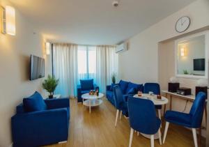 a living room with blue chairs and a table at New Orbi City Luxury Suites in Batumi