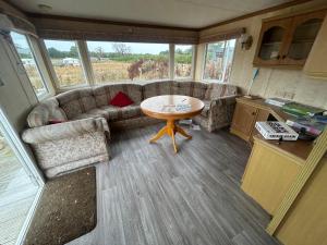 a living room with a couch and a table at Ready Pitched Tent stay Bring your own bedding in Trefnant