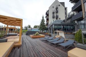 a deck with lounge chairs on top of a building at Шпиці boutique hotel & SPA in Yablunytsya