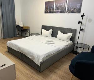 a bedroom with a large bed with two tables at ELA Cotroceni Residence - self check in & free parking in Bucharest