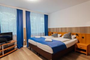 a bedroom with a large bed and a television at Hotel Hanseat Hamburg - Free Parking in Hamburg