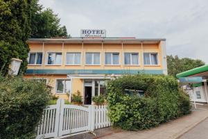 a hotel with a white fence in front of it at Hotel Hanseat Hamburg - Free Parking in Hamburg