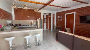a kitchen with a counter and bar with stools at Villa Arcoíris in Paita