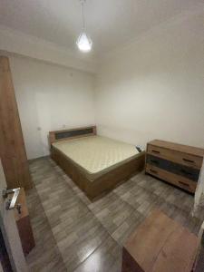 a bedroom with a bed and a dresser in it at At home in Yerevan