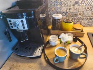 a coffee maker and two cups of coffee on a table at Vila Rychleby Javorník in Javorník