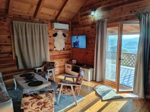 a living room with wooden walls and a large window at Villa NEOM, Sarajevo in Vogošća