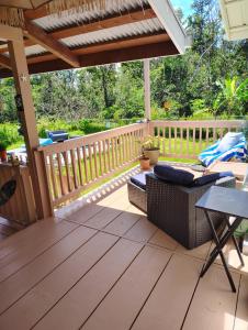 a patio with a wooden deck with a pergola at Hoomaikai Blessings in Keaau
