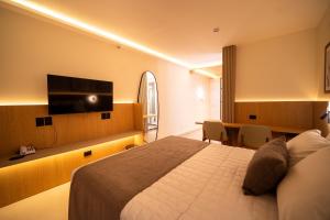 a hotel room with a bed and a desk and a television at Oklahoma Inn in Foz do Iguaçu