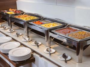 a buffet line with several trays of food at Ibis Lagos Ikeja in Ikeja